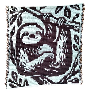 May include: A square, light blue and brown crocheted blanket featuring a sloth design. The sloth is hanging from a tree branch, with leaves surrounding it. The blanket has a fringed edge.