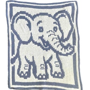 May include: A handmade crochet baby blanket with a blue and white elephant design. The blanket is square with a blue border. The elephant is in the centre and has large ears and a trunk. The blanket is made of yarn.