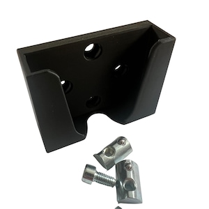 Può includere: Un supporto a parete in plastica nera con quattro fori e una fessura per un dispositivo. Viene fornito con tre viti in metallo argentato e due staffe in metallo argentato.