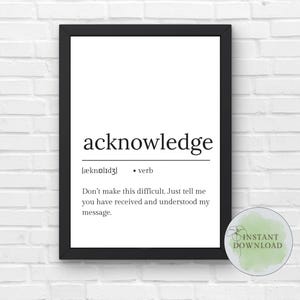 May include: A framed print with the word "acknowledge" in a bold, black font. The definition and a short message are below the word. The print is in a black frame and is against a white brick wall.