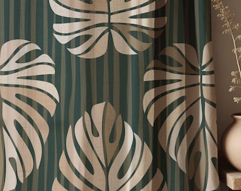 May include: A teal green curtain with a white and beige tropical leaf pattern. The leaves are large and have a textured look.