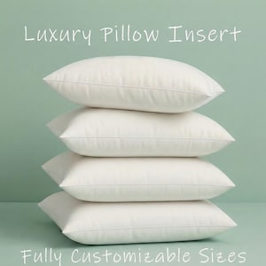 Könnte beinhalten: Vier weiße, rechteckige Kissen übereinander gestapelt. Die Kissen haben eine weiche, abgerundete Form und eine feine Naht an den Rändern. Der Text oben lautet "Luxury Pillow Insert" und unten "Fully Customizable Sizes".
