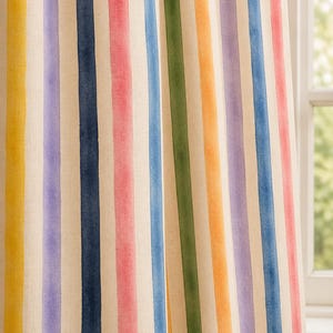 May include: A curtain panel featuring a vertical striped pattern in a watercolor style. The stripes alternate between yellow, purple, dark blue, pink, light blue, green, and orange, all set against a light cream-colored fabric background.