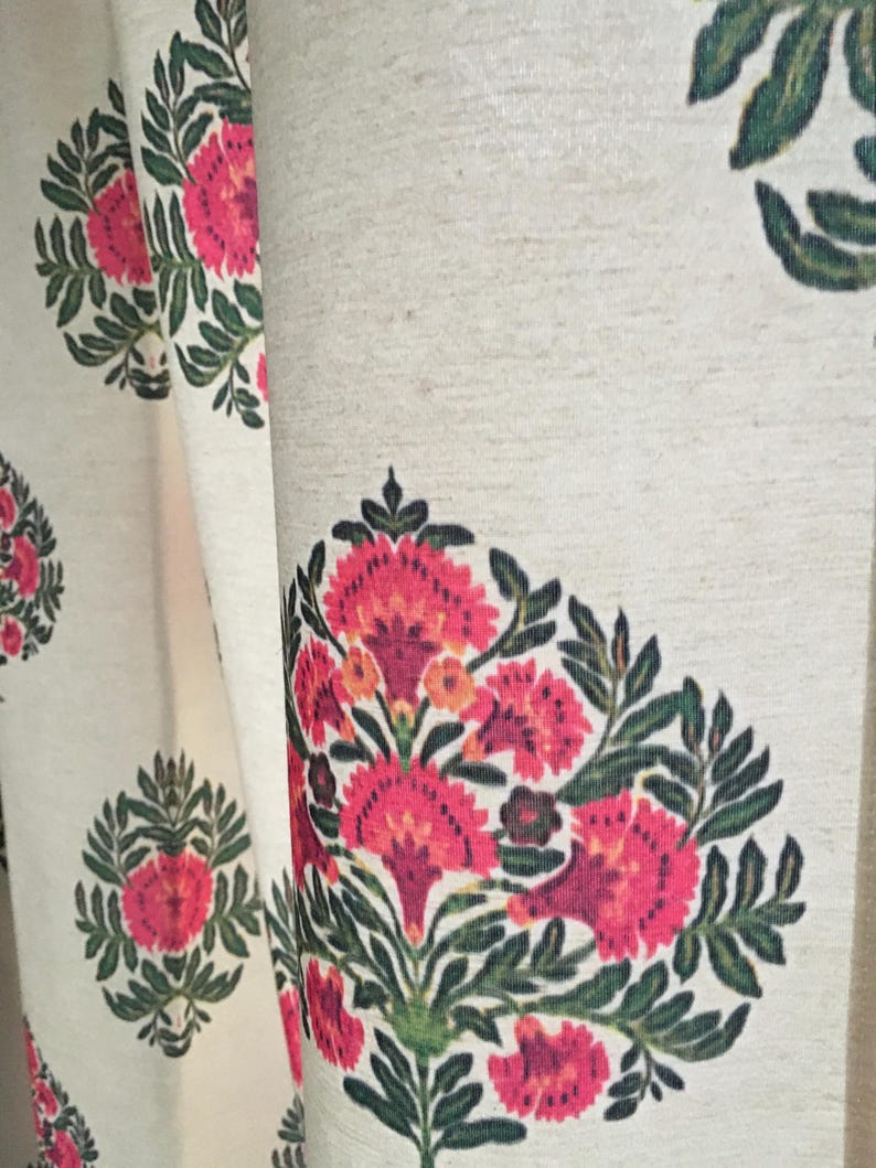May include: White fabric with a repeating pattern of pink and green floral designs. The flowers are stylized and have a vintage look.