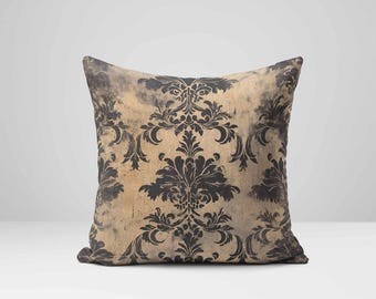 May include: A decorative cushion with a damask pattern in black and gold. The cushion has a distressed look, with faded areas in the gold fabric.