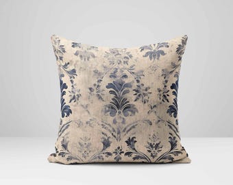 May include: A decorative throw pillow with a beige background and a blue damask pattern.