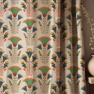 Puede incluir: Tela color crema con un patrón repetido de flores estilizadas en verde, azul, naranja y rojo. El diseño floral recuerda al arte egipcio antiguo, creando un textil único y decorativo.