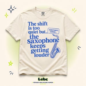 Puede incluir: Una camiseta de manga corta de color crema con texto azul que dice, The shift is too quiet but... the Saxophone keeps getting louder, junto con un pequeño recuadro que dice SOMETHING'S COMING y una ilustración gráfica de un saxofón.