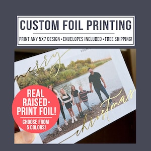 May include: A white 5x7 inch card with a photo of a family of five standing by a river. The words "merry christmas" are written in gold foil on the card. The text "REAL RAISED-PRINT FOIL! CHOOSE FROM 5 COLORS!" is on a red circle.