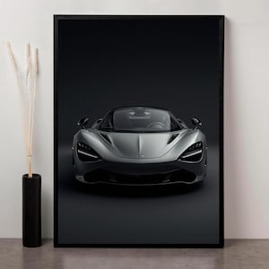 Może przedstawiać: Oprawiony wydruk przedstawiający srebrny samochód sportowy, wyśrodkowany na ciemnym tle. Elegancki design samochodu podkreślają reflektory i zakrzywiona karoseria. Obraz jest w czarnej ramie, tworząc nowoczesną estetykę.