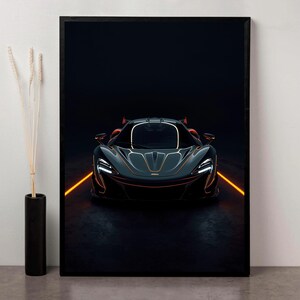 Pode incluir: Impressão emoldurada de um carro esportivo cinza escuro com detalhes de iluminação laranja. O carro está posicionado em uma estrada escura com linhas laranja brilhantes, em um fundo preto. Design moderno e aerodinâmico.