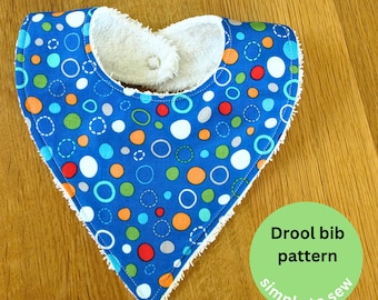 May include: A blue and white drool bib with a white fleece backing. The bib has a colorful circle pattern and is trimmed with white. The text "Drool bib pattern simple to sew" is on a green circle.