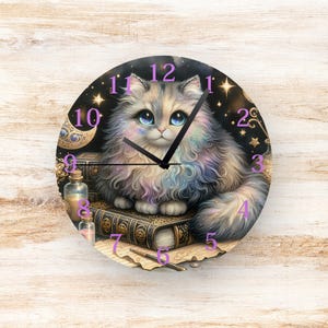 May include: Round wall clock featuring a fluffy cat with blue eyes, sitting on books. The clock face has a starry background, with purple numerals and clock hands. Decorative bottles and a crescent moon are also visible.