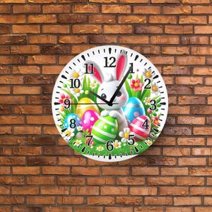 May include: A round Easter-themed wall clock featuring a white bunny with pink ears and colorful Easter eggs. The clock face has black numbers and hands, surrounded by flowers and grass, set against a brick wall.