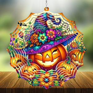 May include: A multi-layered, circular metal wind spinner featuring a vibrant, colorful illustration of a smiling jack-o'-lantern wearing a purple witch hat adorned with bright flowers, surrounded by additional pumpkins and a spider web pattern.