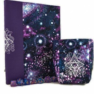 May include: A purple and galaxy-themed dice bag and dice box set. The dice bag and box feature a cosmic design with white starbursts and a white geometric design. A set of multi-sided dice are in front of the bag and box.