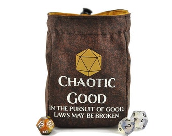 May include: Brown dice bag with the words "CHAOTIC GOOD" and the phrase "IN THE PURSUIT OF GOOD, LAWS MAY BE BROKEN" printed in white. A gold geometric shape is above the words. Three dice are next to the bag.