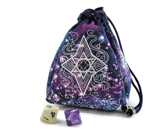 May include: A purple and blue galaxy print dice bag with a white star design and drawstring closure. The bag is sitting on a white surface with two dice beside it.