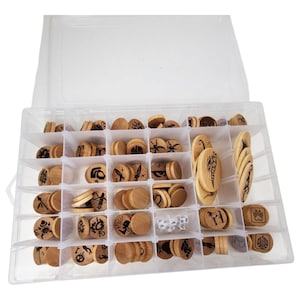 May include: A clear plastic storage box filled with wooden game pieces. The pieces are round and have different designs engraved on them. The box has multiple compartments to organize the pieces.