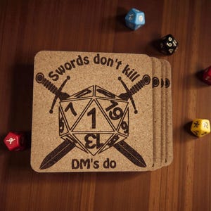 May include: A stack of square cork coasters with a Dungeons & Dragons theme. Each coaster features a black graphic of a 20-sided die with crossed swords and the text "Swords don't kill, DM's do". Several multi-sided dice are scattered around.