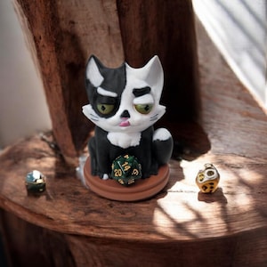black and white cat dice guardian with die 20, TTRPG
