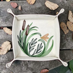 May include: A set of three ceramic mugs with a speckled, matte finish. The mugs are in shades of cream, light gray, and dark gray. Each mug has a simple, minimalist design, perfect for coffee or tea.