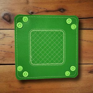 May include: Square green leatherette tray with a stitched diamond pattern in the center. The tray has rounded corners and is secured with six green snap fasteners. White stitching outlines the edges and the inner diamond pattern.