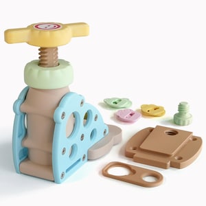 May include: A disassembled toy press in shades of beige, blue, yellow, green, and pink. The press features a screw mechanism, a handle, and a blue support structure. Several small, colorful pieces are scattered around.