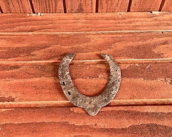 Well worn vintage iron horseshoe. Western cowboy cabin or farmhouse decor.