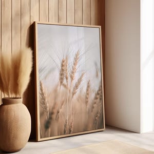 Può includere: Una stampa incorniciata di un primo piano di spighe di grano in un campo. Il grano è di colore marrone chiaro e lo sfondo è un beige morbido e sfocato.