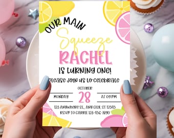 May include: A pink and yellow birthday invitation with a lemon theme. The invitation says "Our Main Squeeze Rachel is turning one!" and includes the date, time, and RSVP information.
