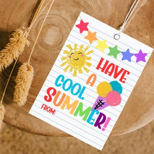 May include: A white tag with a summer theme. The tag features a smiling sun, colourful stars, and an ice cream cone illustration. Text on the tag reads "Have a Cool Summer!" and "From:" in various colours. A string is attached for hanging.
