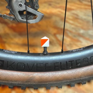 Puede incluir: Primer plano de una rueda de bicicleta negra con una tapa de válvula blanca y naranja. La rueda está etiquetada como "KOVEELITE 30" y "DISC BRAKE ONLY, R22 x 29 MADE IN TAIWAN".