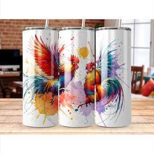 May include: Three white stainless steel tumblers with colorful watercolor rooster designs. The roosters feature vibrant red, orange, yellow, blue, and purple hues, with paint splatter accents. Each tumbler has a silver straw.
