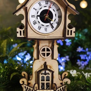 May include: A wooden clock shaped like a house, with a white clock face and Roman numerals. The clock has a decorative balcony and a small window. The clock is made of light brown wood and has a detailed design.