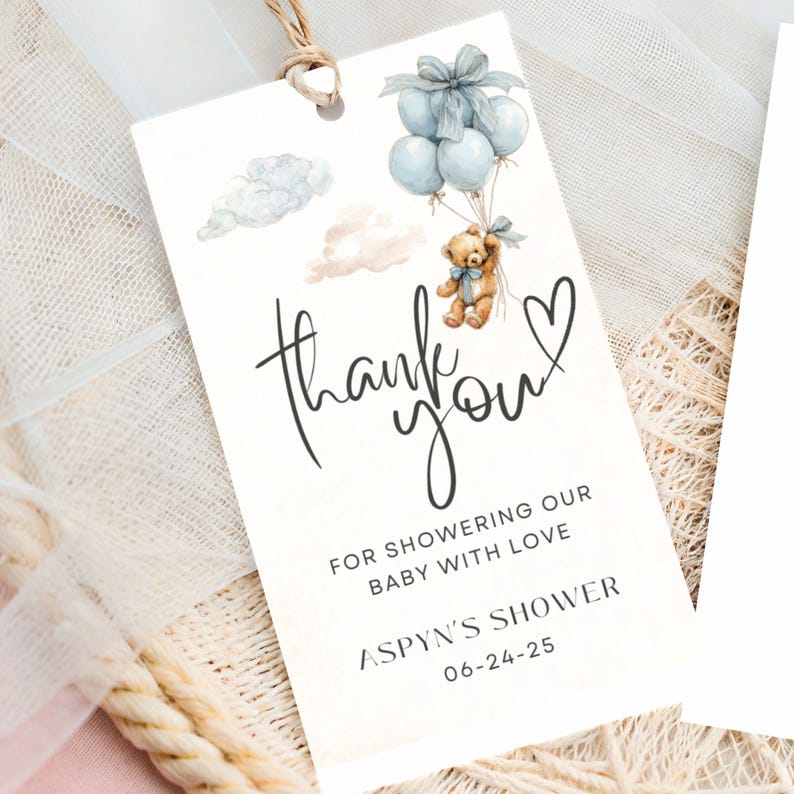 May include: A cream-colored gift tag with a watercolor illustration of a teddy bear carried by blue balloons. The tag reads "thank you" in cursive, with additional text below. A string is attached at the top.