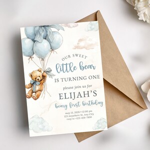 Blue bear first birthday invite template shown on a mockup, highlighting an easy to edit digital invitation for a teddy themed baby boy party.