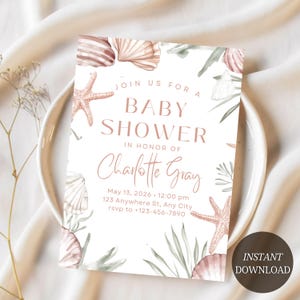 Puede incluir: Una invitación a un baby shower con un diseño de conchas marinas y estrellas de mar. La invitación presenta el texto "Join us for a Baby Shower in Honor of Charlotte Gray" y los detalles del evento. El diseño incluye ilustraciones en acuarela.