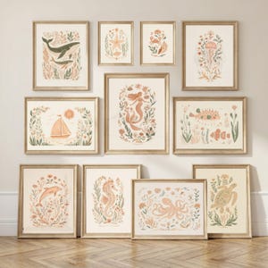 May include: A gallery wall set of eleven framed prints featuring illustrations of marine life including a whale, starfish, crab, jellyfish, sailboat, mermaid, pufferfish, clownfish, dolphin, seahorse, octopus, and sea turtle in muted earth tones.