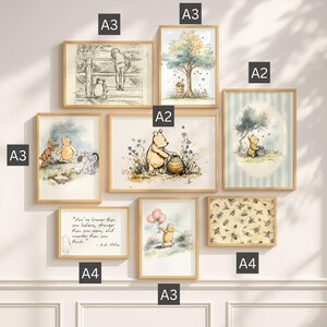 May include: A gallery wall set of eight framed Winnie the Pooh prints in light wood frames. The collection includes illustrations of Pooh, Piglet, Tigger, and Eeyore, a quote print, and a bee pattern, labelled with A2, A3, and A4 size indicators.
