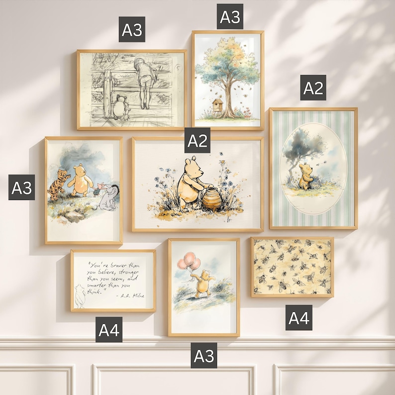 May include: A gallery wall set of eight framed Winnie the Pooh prints in light wood frames. The collection includes illustrations of Pooh, Piglet, Tigger, and Eeyore, a quote print, and a bee pattern, labelled with A2, A3, and A4 size indicators.