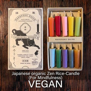 May include: A box of ten Warosoku Daiyo rice bran Japanese candles in assorted colours, including orange, red, pink, yellow, green, light blue, dark green, purple, grey, and brown, with a cardboard box featuring a black cat illustration.