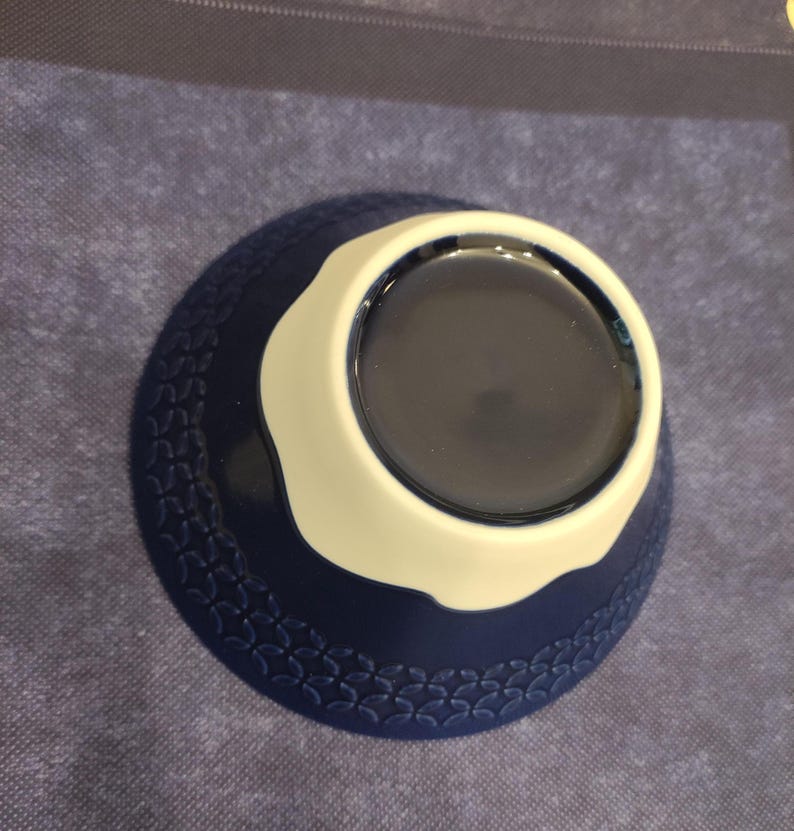 Pu&ograve; includere: Una ciotola in ceramica blu e bianca con un motivo decorativo attorno al bordo. La ciotola &egrave; vuota.