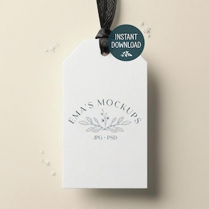 Puede incluir: Una etiqueta blanca con el texto "EMA'S MOCKUPS" y "JPG + PSD" en verde oscuro. La etiqueta está suspendida por una cinta negra. Un círculo verde oscuro con las palabras "INSTANT DOWNLOAD" está unido a la cinta.