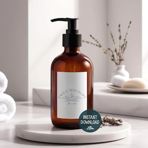 May include: Amber glass bottle with a black pump dispenser, featuring a white label with floral design and the text "Ema's Mockups". The bottle sits on a white marble platform. A teal "Instant Download" sticker is visible.