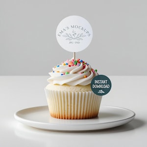 Op de afbeelding: Een vanille cupcake met witte frosting en kleurrijke sprinkles op een wit bord. Een ronde topper met de tekst "Ema's Mockups" en "JPG + PSD" zit in de cupcake. Een groene cirkel met "Instant Download" staat aan de zijkant.