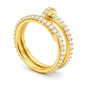 Könnte beinhalten: Ein goldener Ring im Nagel-Design mit einer Wickeloptik, die sich um den Finger legt. Das Band ist an den Außenkanten mit zahlreichen kleinen, klaren, rund geschliffenen Steinen besetzt, die einen funkelnden Effekt auf dem polierten Gelbgold erzeugen.