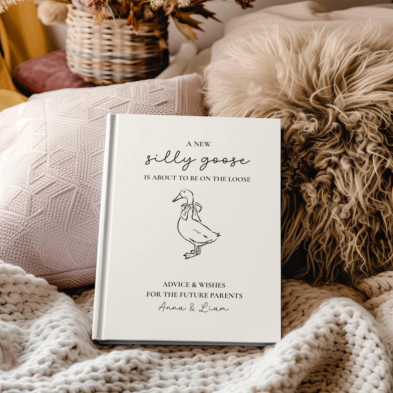 Op de afbeelding: Een wit hardcover boek met de tekst "A New Silly Goose Is About To Be On The Loose" en "Advice & Wishes For The Future Parents Anna & Liam". De omslag toont een lijntekening van een gans.