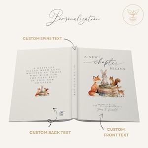 May include: Open book with a watercolor illustration of woodland animals. The cover reads "A New Chapter Begins" with space for custom text. The spine and back cover also have text, with a QR code on the back.