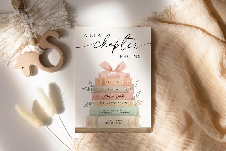 May include: Baby shower invitation with the text "A New Chapter Begins." The invitation features a stack of books with a pink bow on top. The invitation includes the name Amelia Smith and event details.
